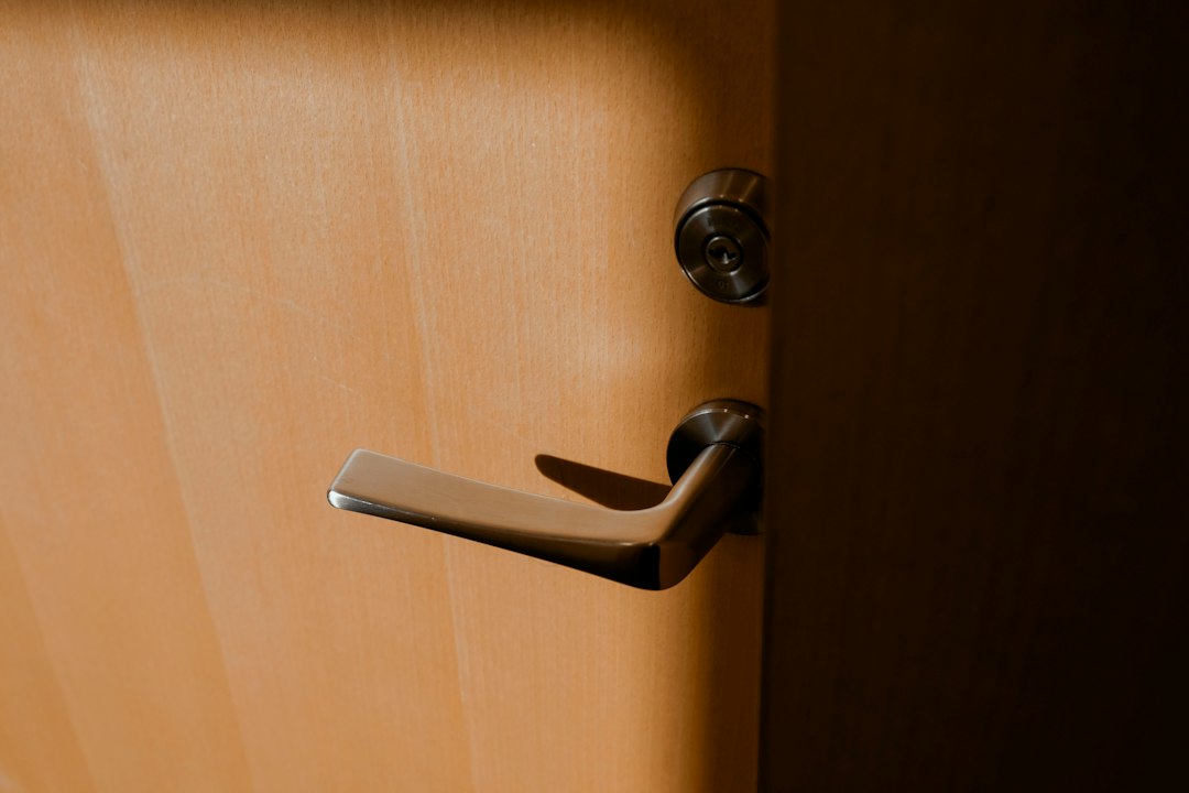 A real door lever and key cylinder on a wooden door.