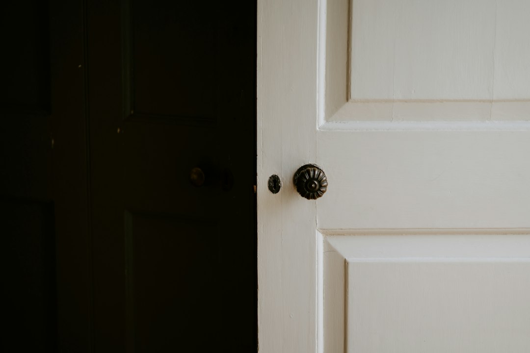 A traditional door knob and keyhole on a white painted door.