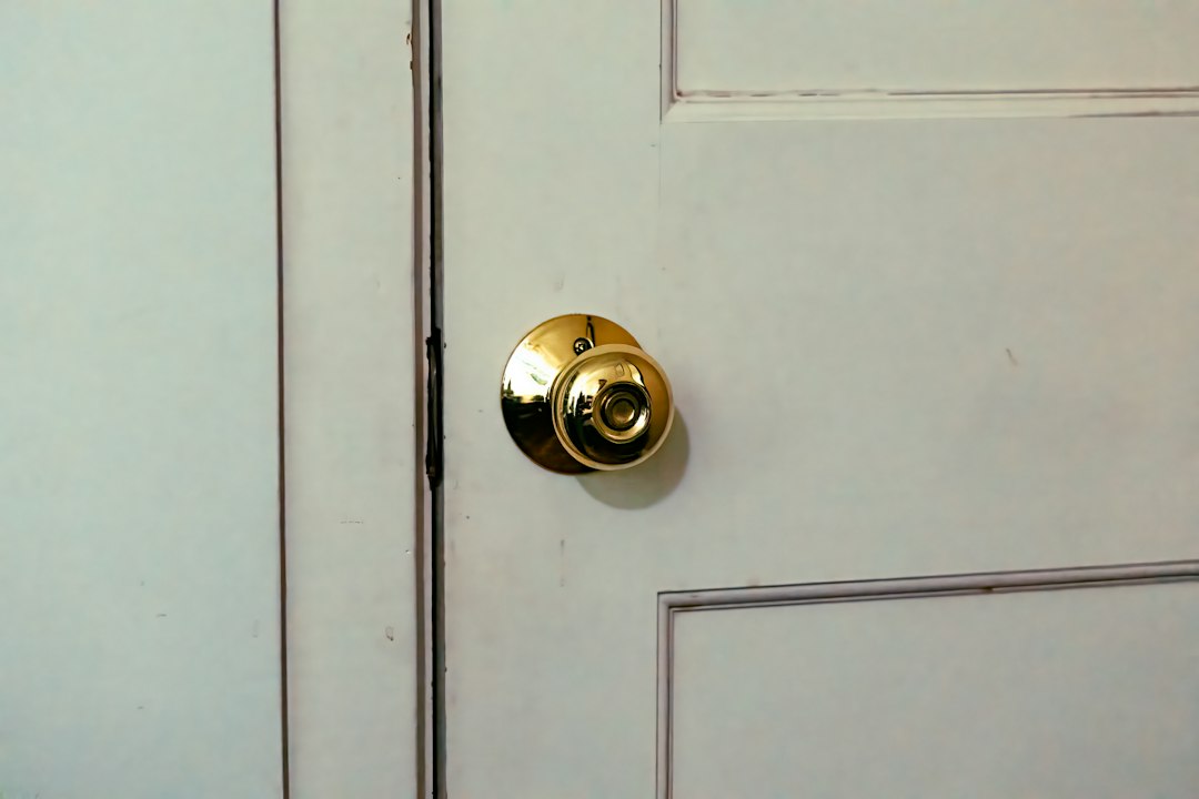 A real brass residential door knob on a white door.