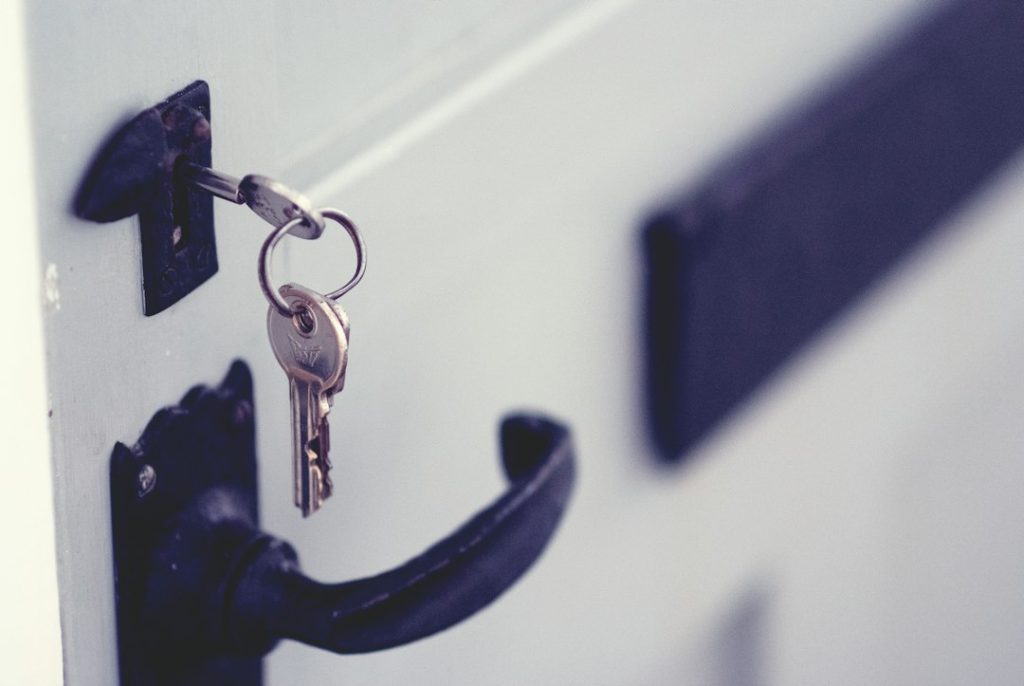 House keys inserted in a cottage-style door lock.