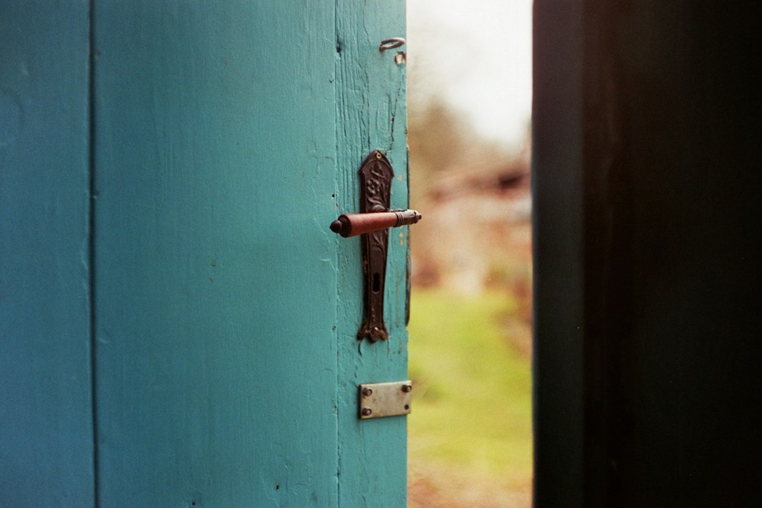 A weathered blue door with its original handle and lock.