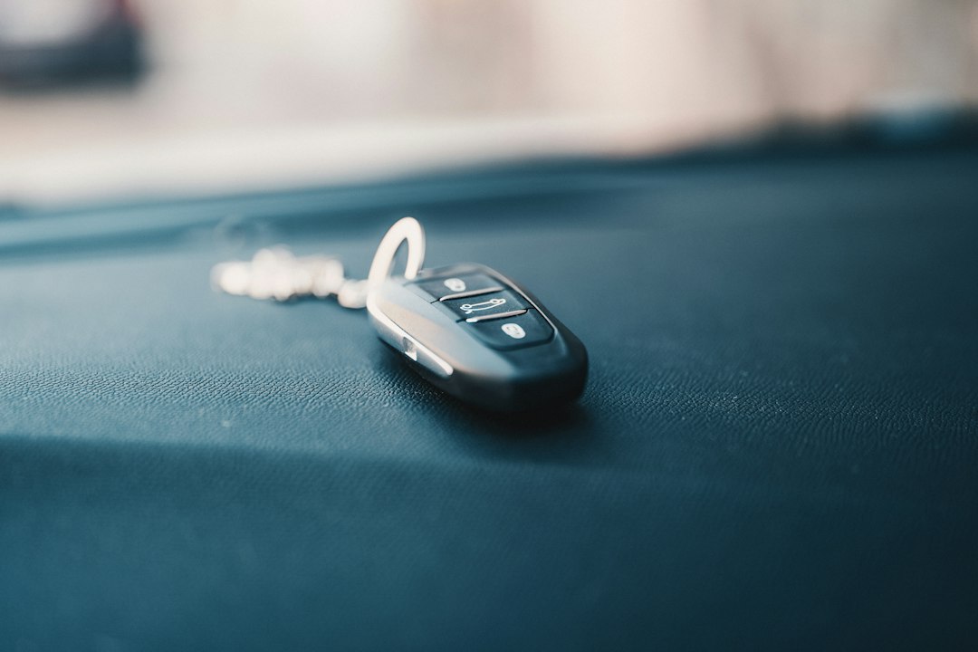 A real automotive key fob resting on a vehicle dashboard.